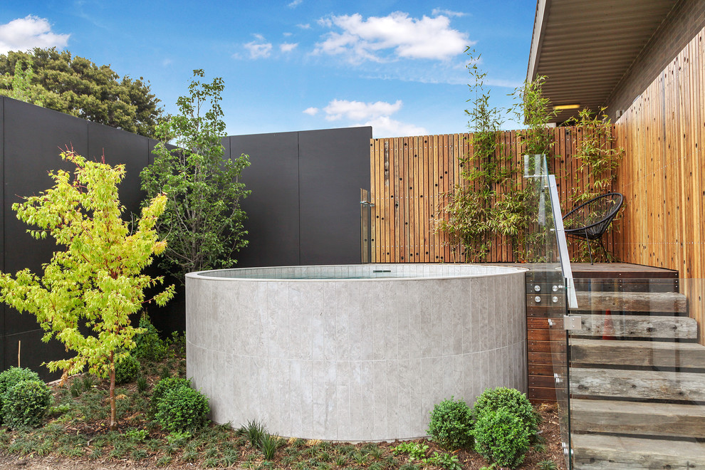 Cette photo montre une piscine hors-sol et arrière tendance de taille moyenne et ronde avec une terrasse en bois.
