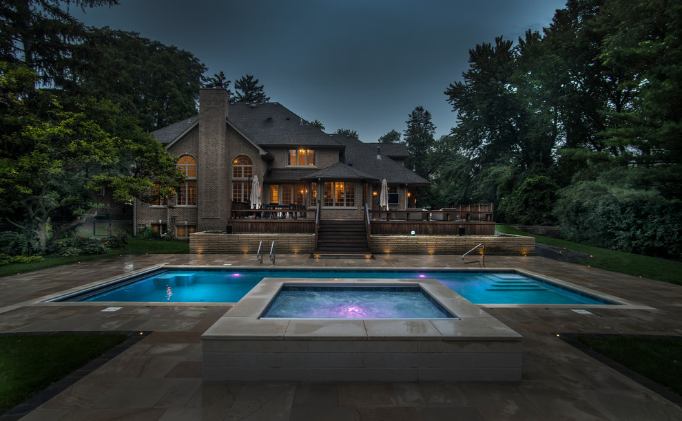 Imagen de piscinas y jacuzzis alargados tradicionales de tamaño medio rectangulares en patio trasero con adoquines de hormigón