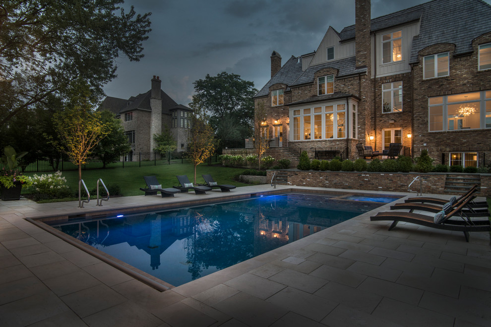 Diseño de piscinas y jacuzzis alargados clásicos de tamaño medio rectangulares en patio trasero con adoquines de piedra natural