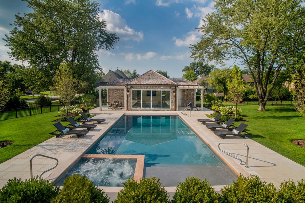 На фото: прямоугольный бассейн среднего размера на заднем дворе в классическом стиле с джакузи и покрытием из каменной брусчатки с