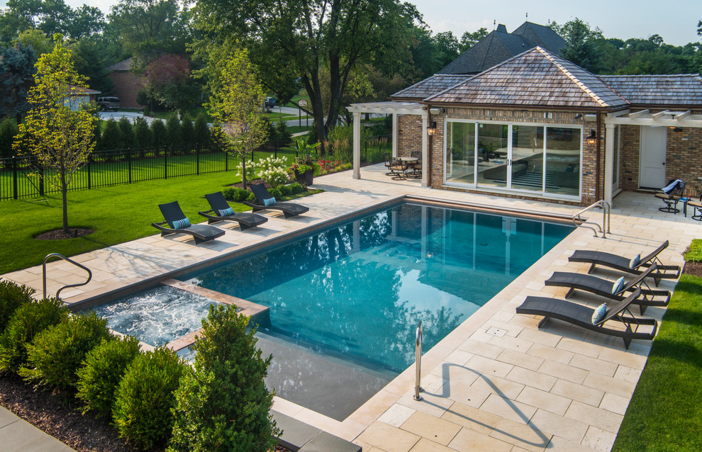 Foto de piscinas y jacuzzis alargados clásicos de tamaño medio rectangulares en patio trasero con adoquines de piedra natural