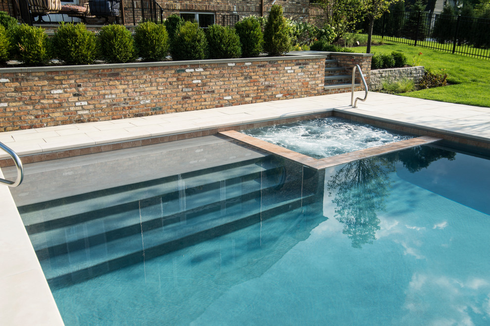 На фото: спортивный, прямоугольный бассейн среднего размера на заднем дворе в классическом стиле с джакузи и покрытием из каменной брусчатки с