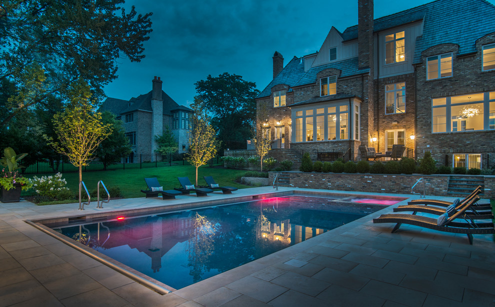 Imagen de piscinas y jacuzzis alargados clásicos de tamaño medio rectangulares en patio trasero con adoquines de piedra natural