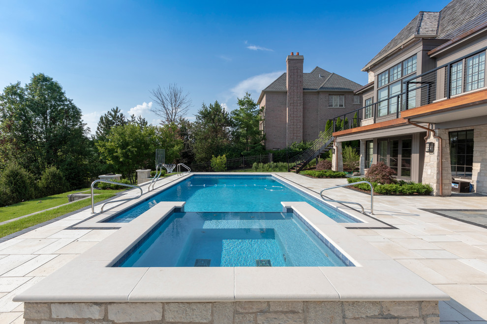 Mittelgroßer Klassischer Pool hinter dem Haus in rechteckiger Form mit Natursteinplatten in Chicago