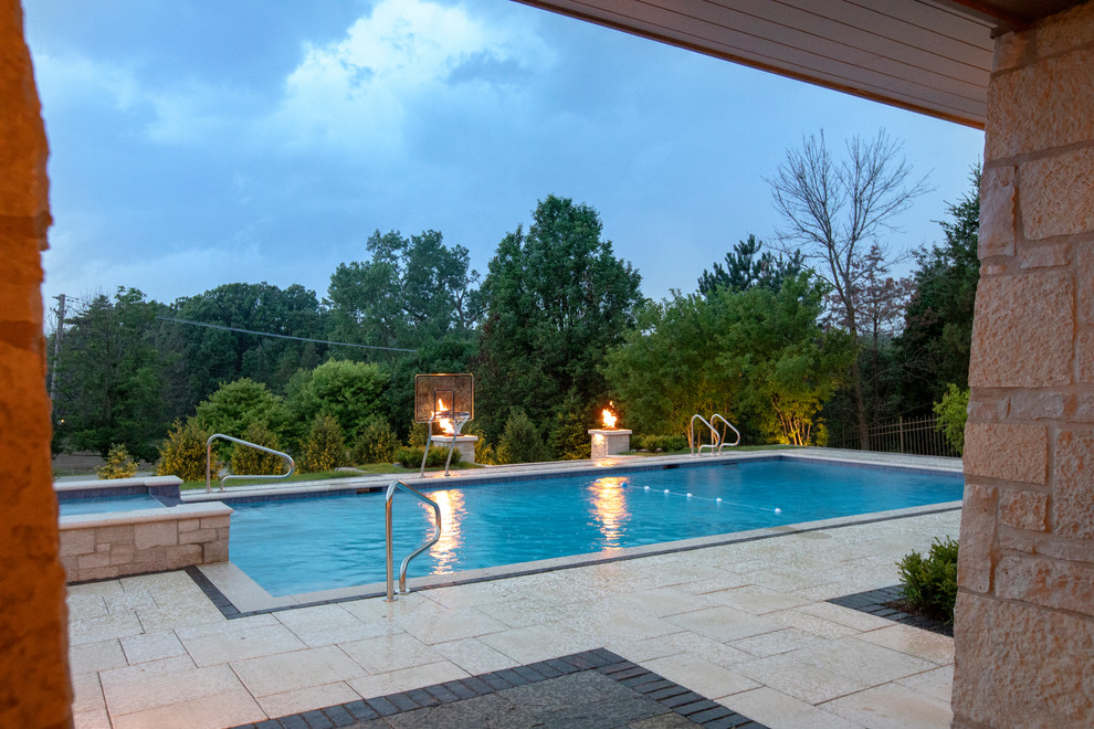 Immagine di una piscina monocorsia chic rettangolare di medie dimensioni e dietro casa con una vasca idromassaggio e pavimentazioni in pietra naturale