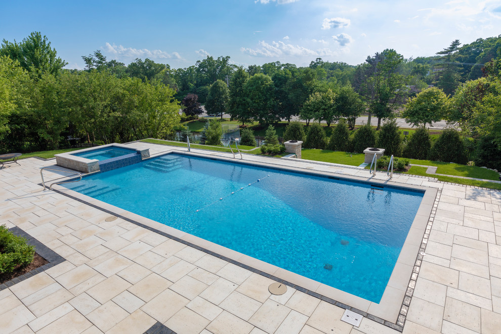 Ispirazione per una piscina monocorsia classica rettangolare di medie dimensioni e dietro casa con una vasca idromassaggio e pavimentazioni in pietra naturale