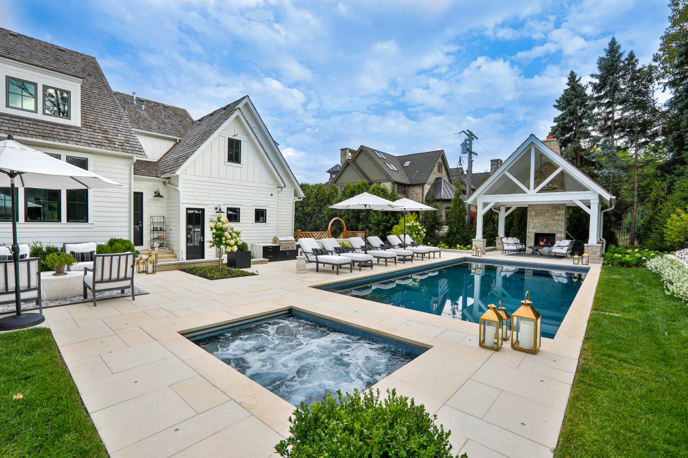 Esempio di una piscina monocorsia country rettangolare di medie dimensioni e dietro casa con una vasca idromassaggio e pavimentazioni in pietra naturale