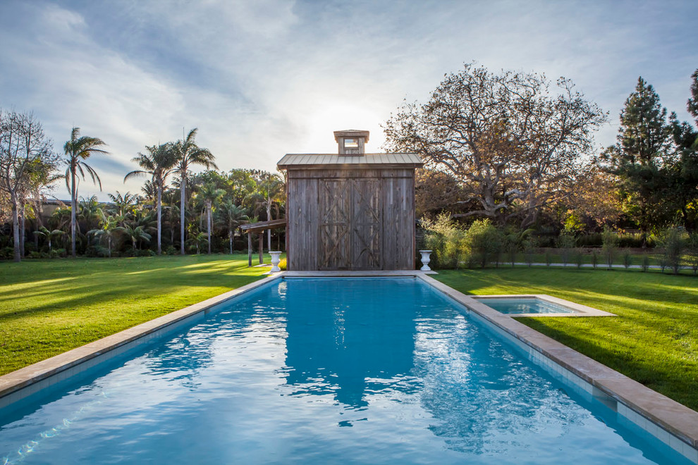 Идея дизайна: спортивный, прямоугольный бассейн на заднем дворе в стиле кантри с домиком у бассейна и покрытием из каменной брусчатки