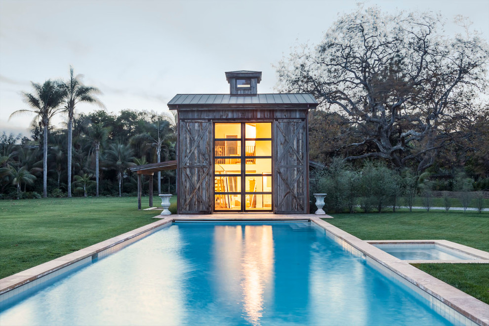 Пример оригинального дизайна: спортивный, прямоугольный бассейн на заднем дворе в стиле кантри с домиком у бассейна и покрытием из каменной брусчатки