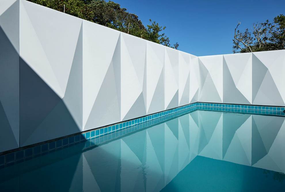 Imagen de piscina actual de tamaño medio rectangular en patio con privacidad y entablado