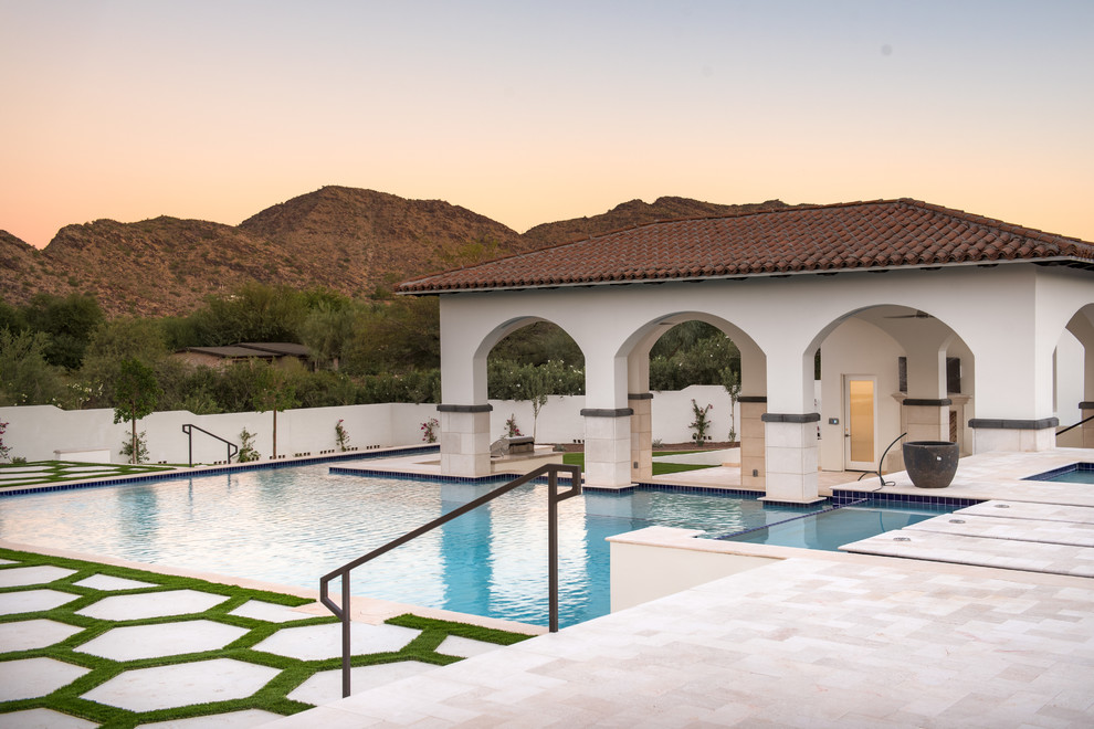 Imagen de piscina con fuente elevada actual grande en forma de L en patio trasero con suelo de baldosas