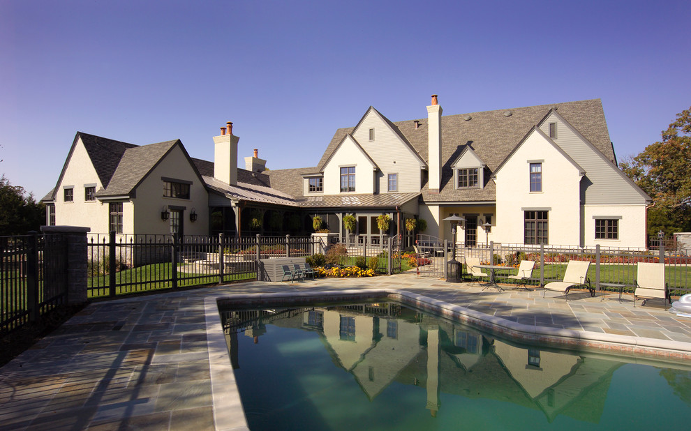 На фото: большой бассейн произвольной формы на заднем дворе в классическом стиле с покрытием из каменной брусчатки с