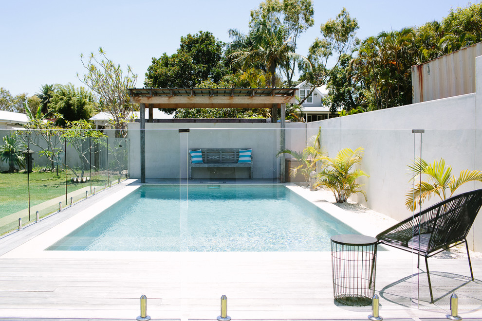 Foto de piscina alargada actual de tamaño medio rectangular en patio trasero con entablado