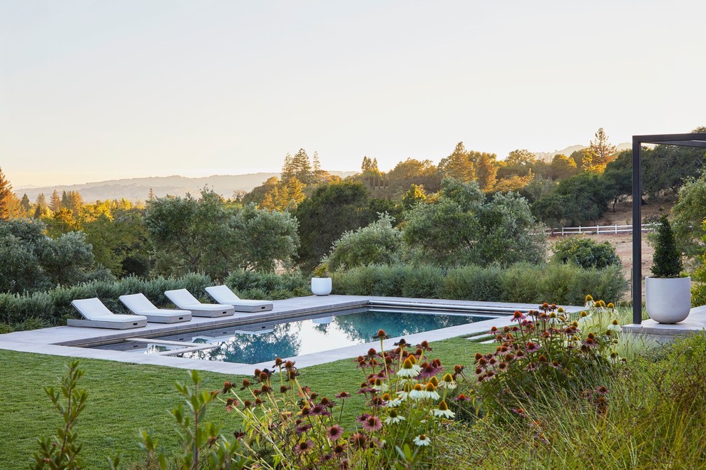 Diseño de piscinas y jacuzzis alargados campestres de tamaño medio rectangulares en patio trasero con adoquines de hormigón