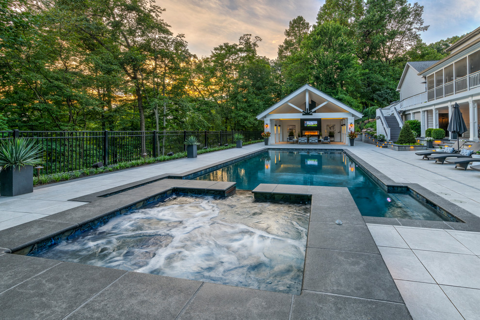 Diseño de casa de la piscina y piscina alargada tradicional renovada grande rectangular en patio trasero con adoquines de hormigón