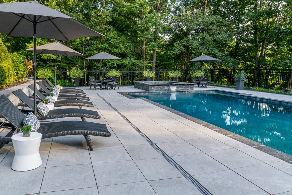 Imagen de casa de la piscina y piscina alargada tradicional renovada grande rectangular en patio trasero con adoquines de hormigón