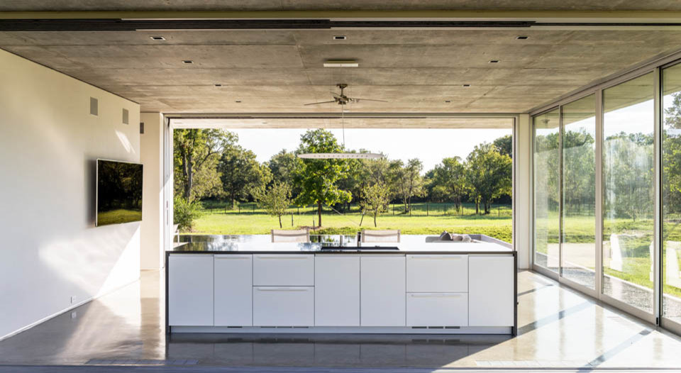 Diseño de casa de la piscina y piscina alargada minimalista de tamaño medio rectangular en patio trasero con losas de hormigón