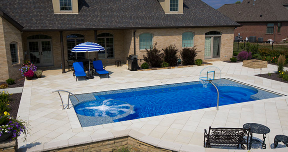 На фото: спортивный, прямоугольный бассейн среднего размера на заднем дворе в стиле модернизм с джакузи и покрытием из каменной брусчатки