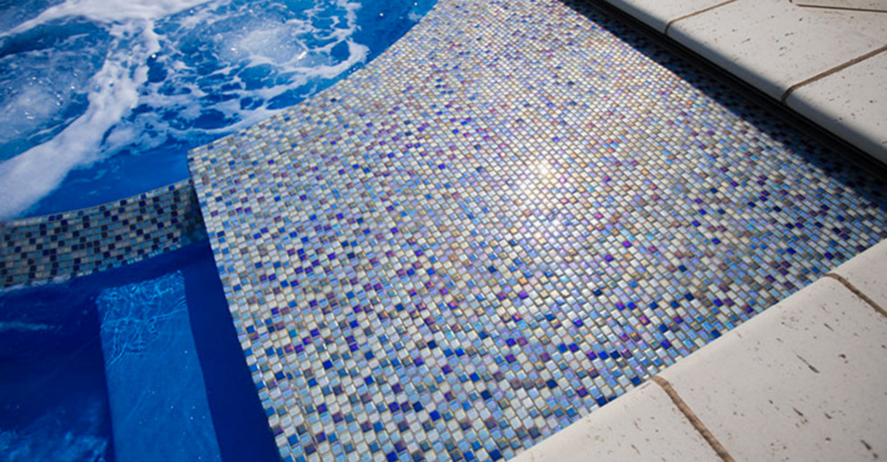 Foto de piscinas y jacuzzis alargados modernos de tamaño medio rectangulares en patio trasero con adoquines de piedra natural