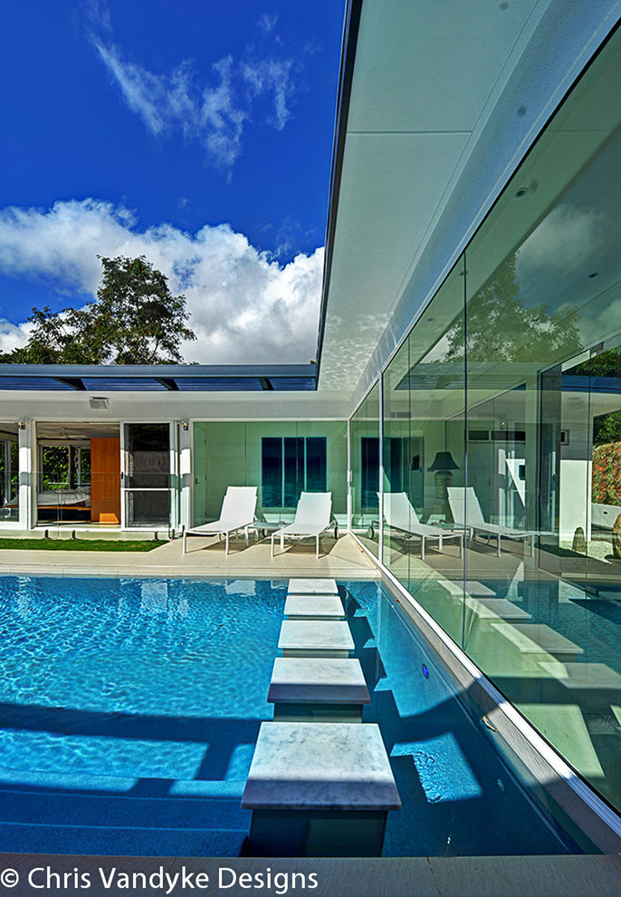 Imagen de piscina infinita retro grande rectangular en patio con suelo de baldosas