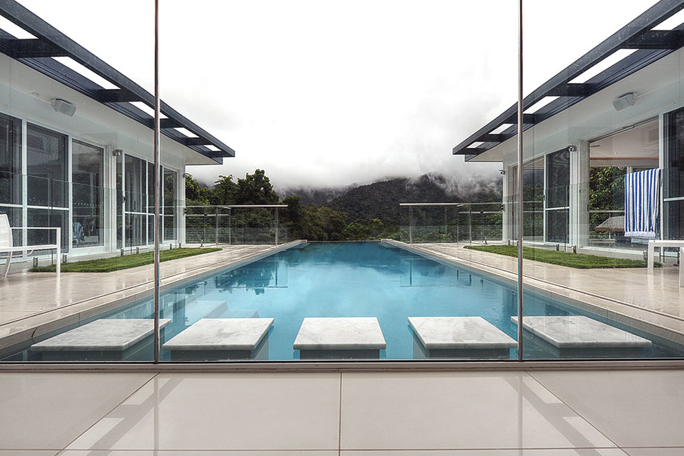 Imagen de piscina infinita vintage grande rectangular en patio con suelo de baldosas