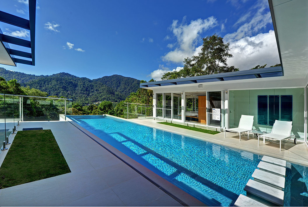 Immagine di una grande piscina a sfioro infinito minimalista rettangolare in cortile con piastrelle
