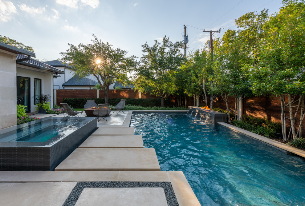 Foto de piscina con fuente alargada contemporánea grande rectangular en patio trasero con losas de hormigón
