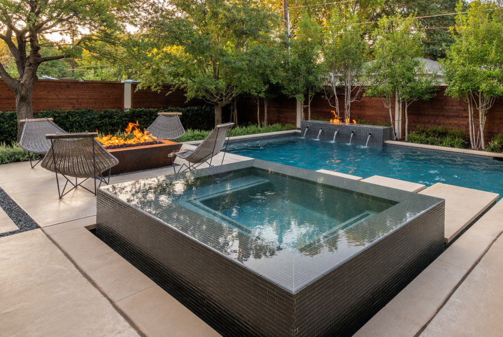 Ispirazione per una grande piscina monocorsia contemporanea rettangolare dietro casa con fontane e lastre di cemento