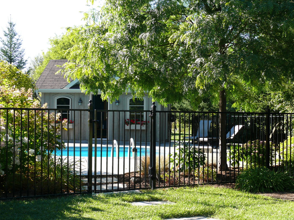 Ispirazione per una grande piscina monocorsia tradizionale a "C" dietro casa con cemento stampato e una dépendance a bordo piscina