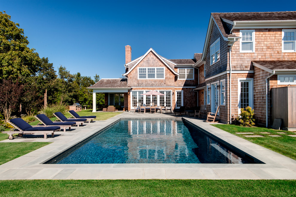 This is an example of a classic back rectangular swimming pool in New York with stamped concrete.