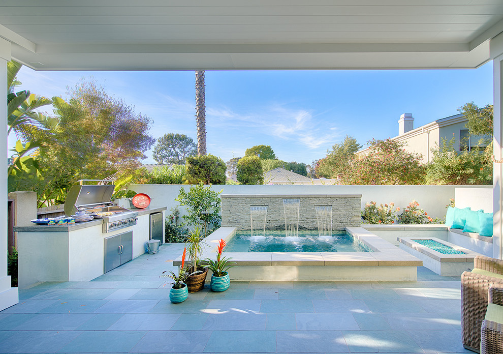 Esempio di una piscina stile marino rettangolare di medie dimensioni e dietro casa con una vasca idromassaggio e pavimentazioni in pietra naturale
