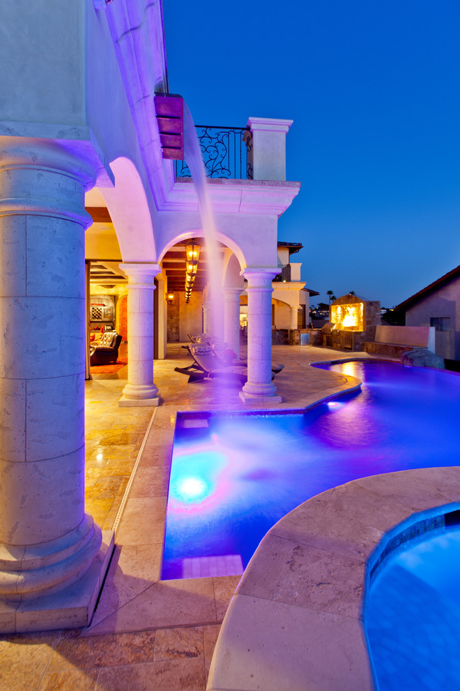 Geräumiger Mediterraner Infinity-Pool neben dem Haus in individueller Form mit Wasserspiel und Natursteinplatten in San Diego