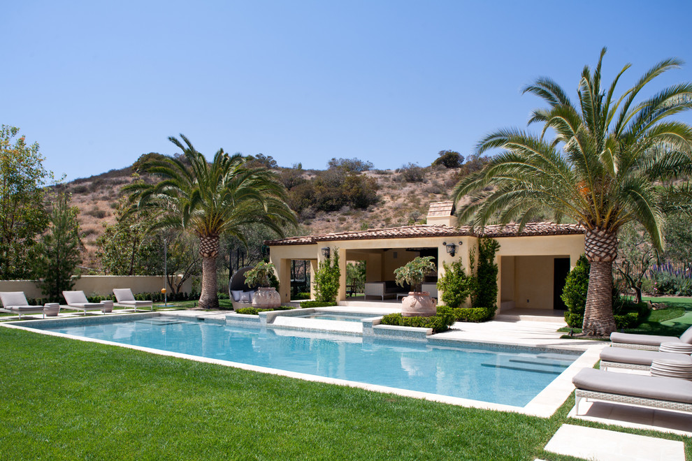Esempio di una grande piscina monocorsia mediterranea rettangolare dietro casa con una vasca idromassaggio