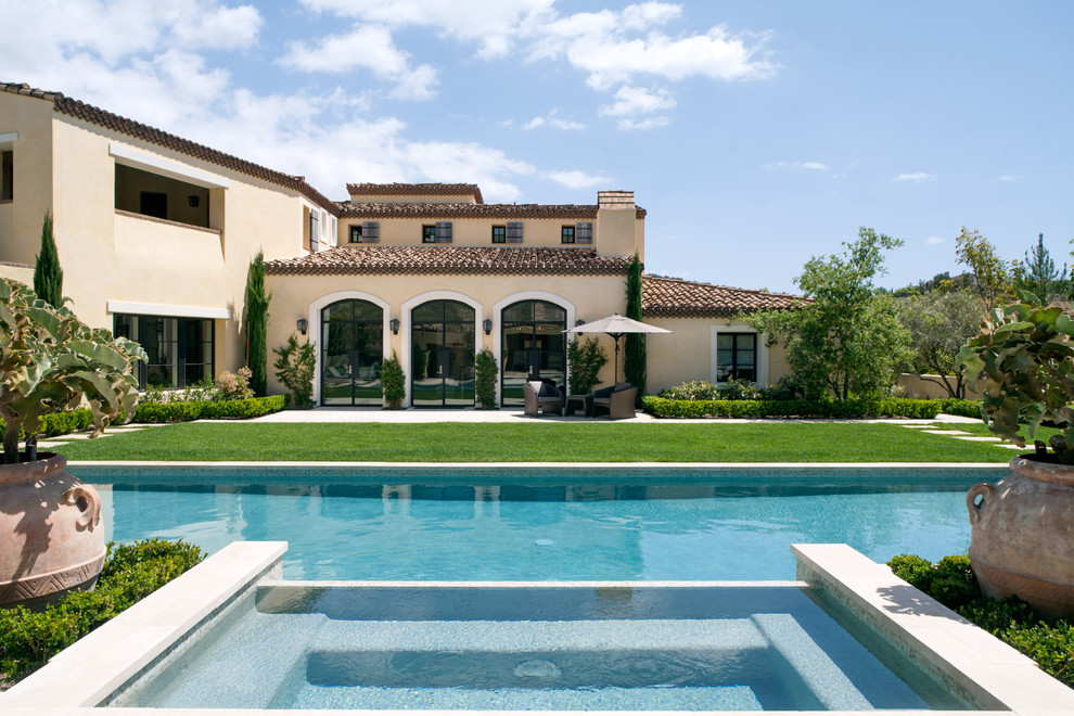 Ispirazione per una grande piscina monocorsia mediterranea rettangolare dietro casa con una vasca idromassaggio