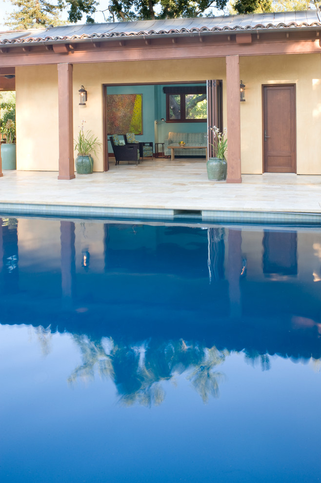 Inspiration pour un grand Abris de piscine et pool houses arrière méditerranéen rectangle avec des pavés en pierre naturelle.