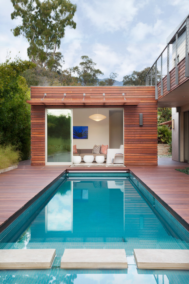 Idée de décoration pour une piscine arrière design rectangle et de taille moyenne avec une terrasse en bois.