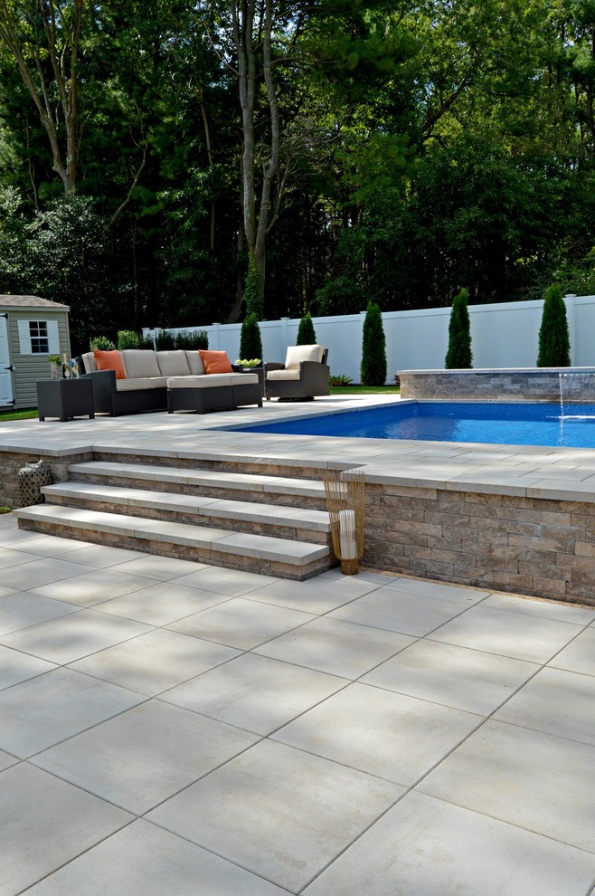 Modelo de piscina elevada clásica a medida en patio trasero con adoquines de ladrillo