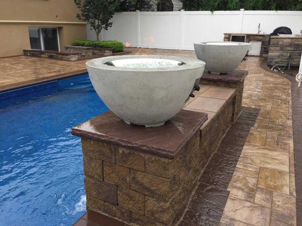 Large elegant backyard concrete paver and rectangular lap pool fountain photo in New York