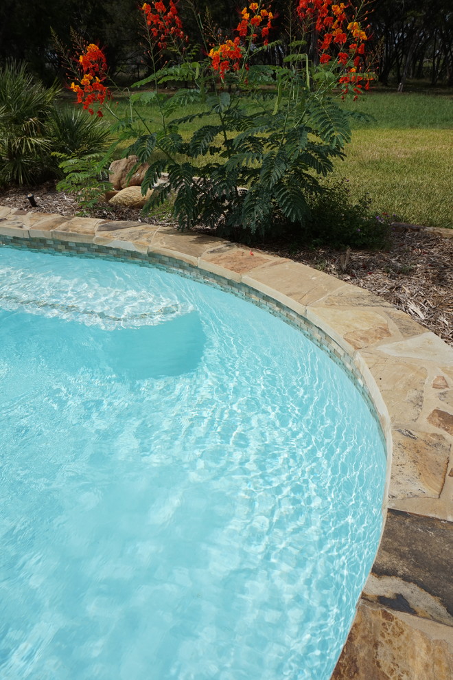 Идея дизайна: большой естественный бассейн в форме фасоли на заднем дворе в стиле рустика с фонтаном и покрытием из каменной брусчатки
