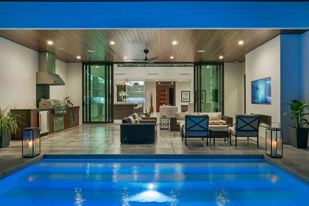 Ispirazione per una piccola piscina monocorsia minimalista personalizzata dietro casa con fontane e lastre di cemento