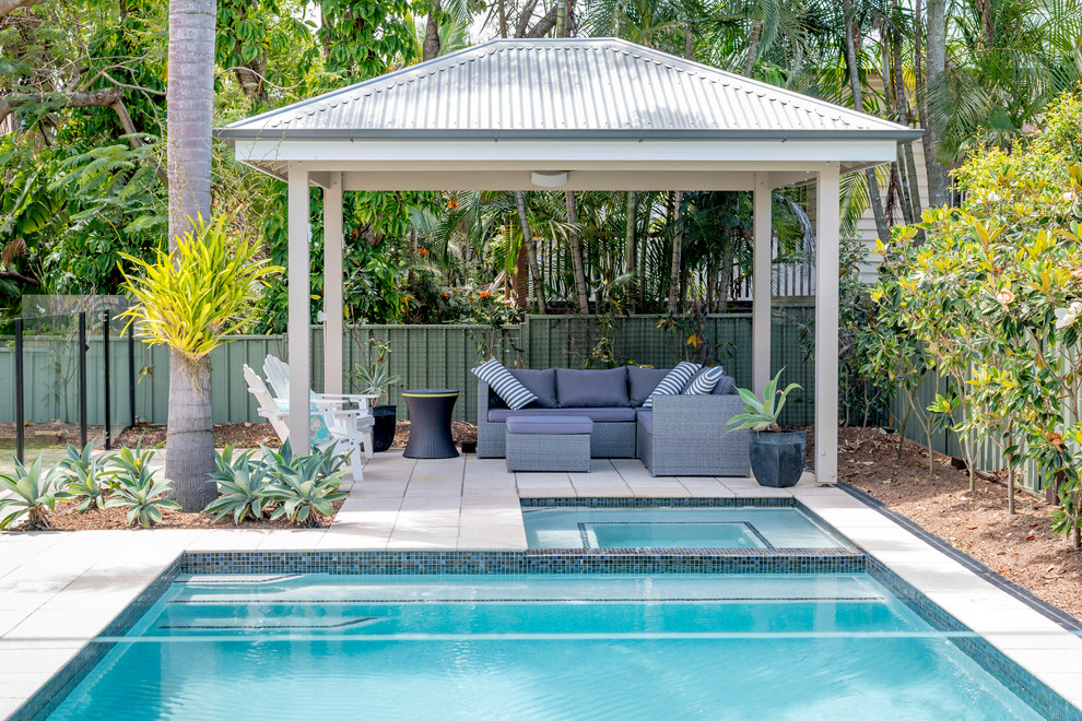 Imagen de piscinas y jacuzzis alargados exóticos de tamaño medio rectangulares en patio trasero con adoquines de piedra natural