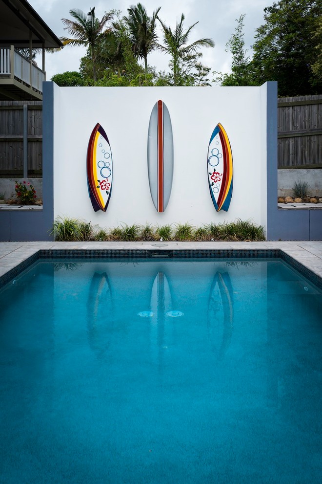 На фото: спортивный, прямоугольный бассейн среднего размера на заднем дворе в современном стиле