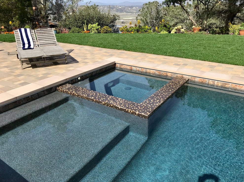 Foto di una grande piscina monocorsia mediterranea rettangolare dietro casa con una vasca idromassaggio e pavimentazioni in cemento