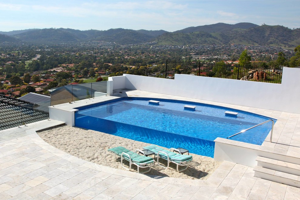 Idée de décoration pour une grande piscine sur toit hors-sol méditerranéenne sur mesure.