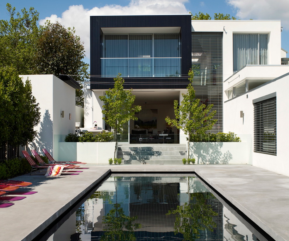 Свежая идея для дизайна: спортивный, прямоугольный бассейн на заднем дворе в современном стиле с покрытием из бетонных плит - отличное фото интерьера