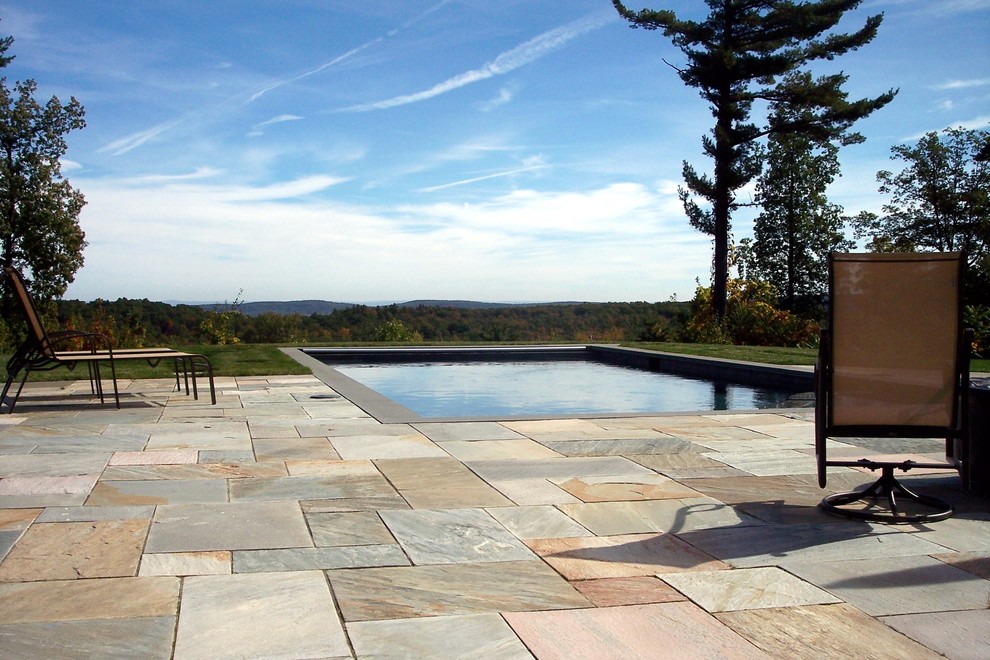 Foto de piscinas y jacuzzis alargados clásicos renovados grandes rectangulares en patio trasero con suelo de baldosas