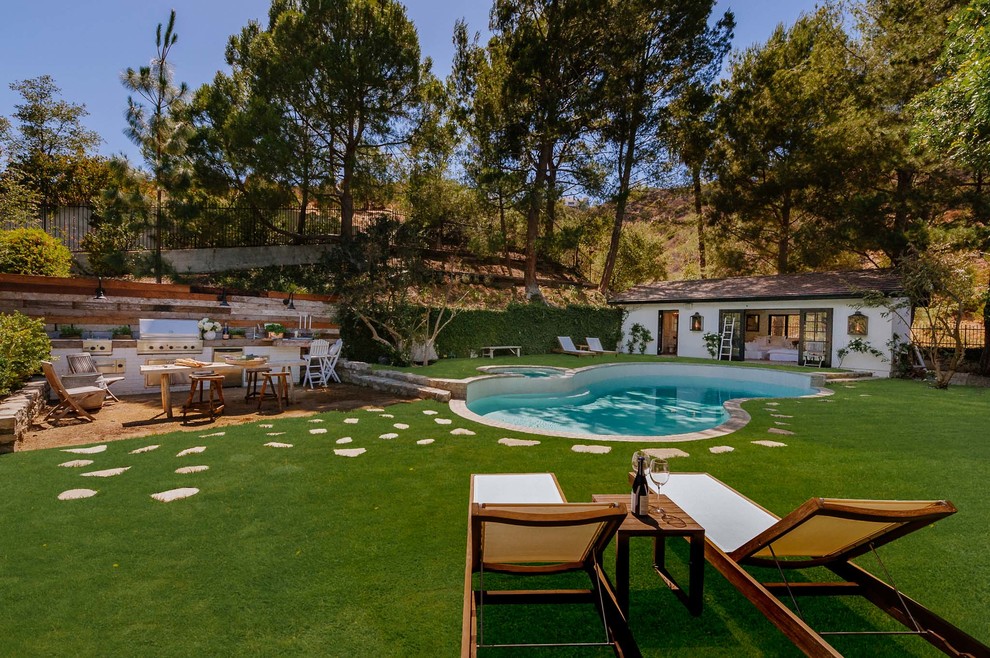 Modelo de casa de la piscina y piscina natural mediterránea grande tipo riñón en patio trasero
