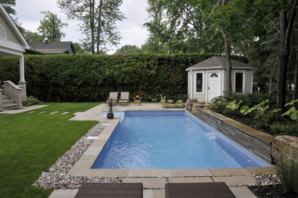 Maritimer Pool hinter dem Haus in rechteckiger Form mit Wasserspiel und Natursteinplatten in Montreal