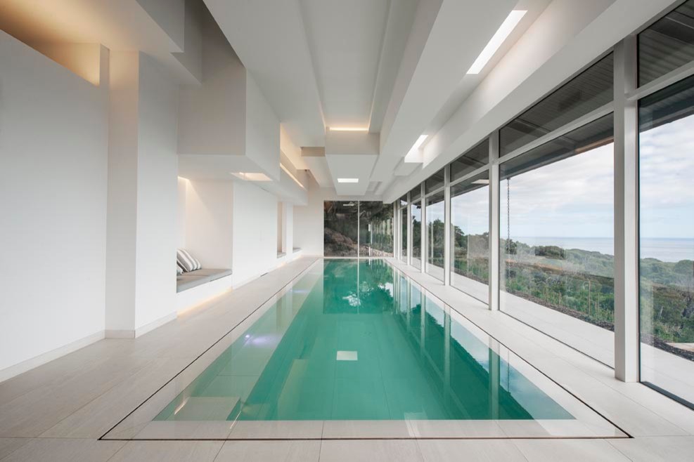 Ejemplo de casa de la piscina y piscina contemporánea grande rectangular y interior con suelo de baldosas