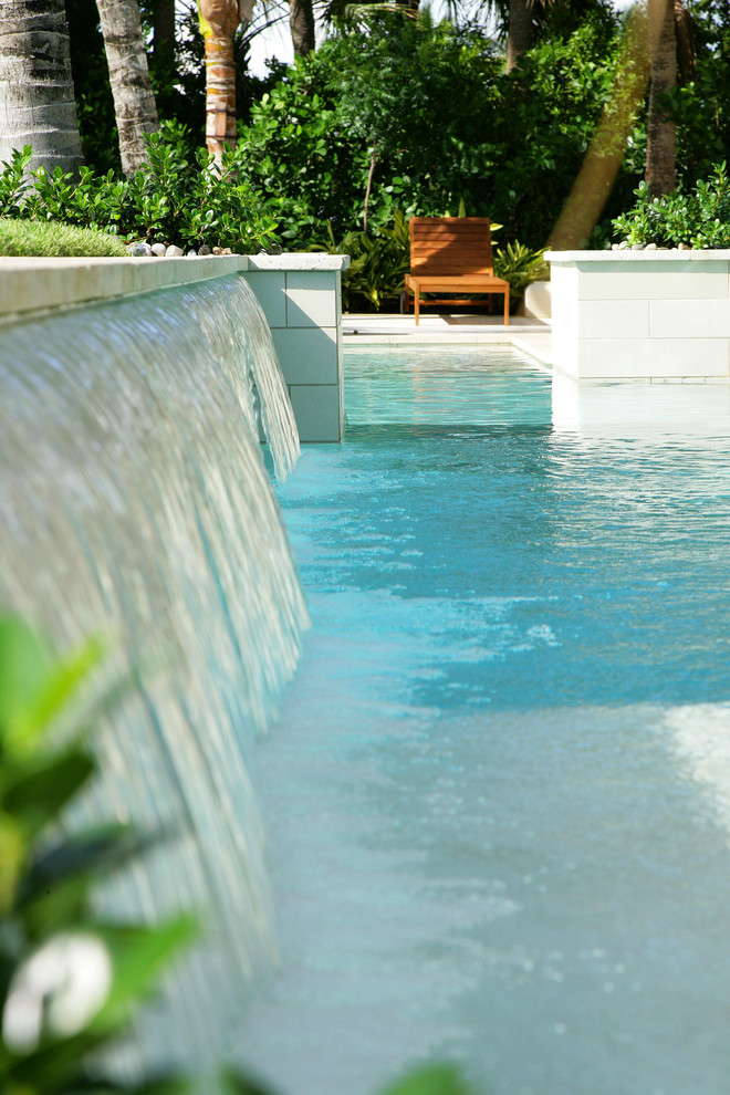 Modelo de piscina con fuente tropical grande a medida en patio trasero